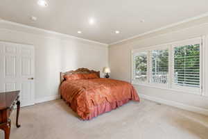 Bedroom featuring light colored carpet, crown molding, and recessed lighting