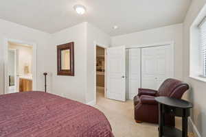Bedroom with light colored carpet and a closet