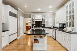 Kitchen with open shelves, white cabinets, ornamental molding, and recessed lighting