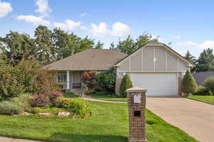 View of front of house featuring a front yard, driveway, an attached garage, and stucco siding