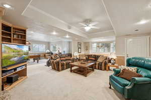 Carpeted living area with recessed lighting, plenty of natural light, ornamental molding, a tray ceiling, and ceiling fan