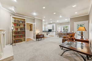Living area with light colored carpet, ornamental molding, recessed lighting, french doors, and an office area