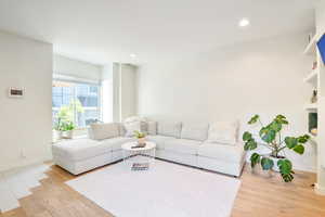 Living area featuring light wood finished floors and recessed lighting