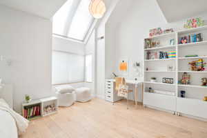 Game room with vaulted ceiling and wood finished floors