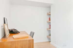 Office with baseboards and light wood-type flooring