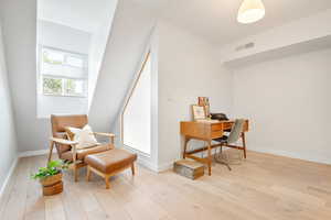 Living area with light wood-style flooring and an office area