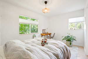 Bedroom featuring wood finished floors and multiple windows