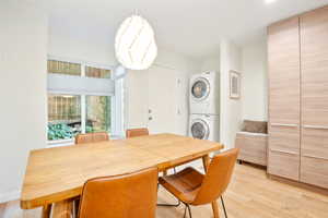 Dining room featuring stacked washer and clothes dryer and light wood finished floors