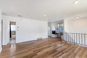 Looking from the far side of the living room toward the kitchen and entry stairs