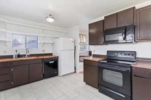 Kitchen featuring open shelves, electric appliances, and laminate countertops
