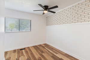 Main bedroom with brick decor on one wall.