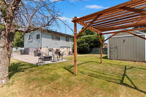 View of yard featuring a patio area, a shed, and a neat pergola.