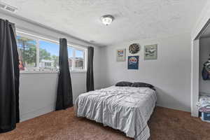 Bedroom featuring carpet and a textured ceiling