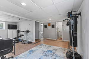 Exercise area with a drop ceiling, tile patterned floors, and recessed lighting