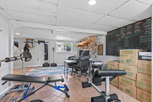 Exercise area with a paneled ceiling and tile patterned flooring