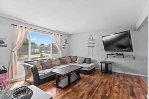 Living area with wood finished floors and a textured ceiling