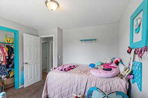 Carpeted bedroom with a closet