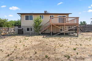 Back of house with stairs, a wooden deck, and a fenced backyard