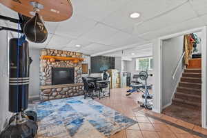 Living room with a paneled ceiling, tile patterned floors, an office area, recessed lighting, and stairs