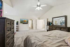 Bedroom with light carpet, a ceiling fan, high vaulted ceiling, and arched walkways