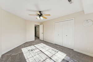 Unfurnished bedroom featuring carpet floors, a closet, and a ceiling fan