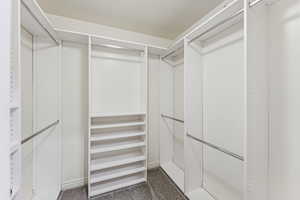 Walk in closet with dark colored carpet