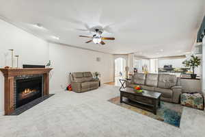 Living area featuring arched walkways, carpet flooring, crown molding, recessed lighting, and a fireplace