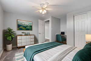 VIRTUALLY STAGED Carpeted bedroom with a closet, an office area, and ceiling fan