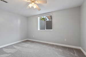 Carpeted empty room featuring a ceiling fan and a textured ceiling
