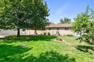 Back of house with a fire pit and brick siding