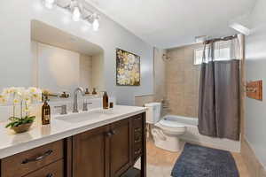 VIRTUALLY STAGED Full bathroom featuring vanity, shower / tub combo, and tile patterned floors