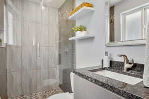 Full bathroom featuring healthy amount of natural light, a stall shower, and vanity