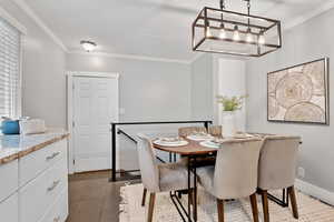 Tiled dining room featuring crown molding