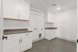 Laundry area with cabinet space, hookup for an electric dryer, and washer hookup