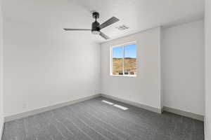 Carpeted spare room featuring baseboards and a ceiling fan