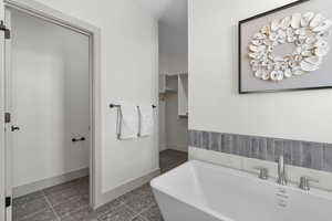 Full bath featuring a bath and baseboards