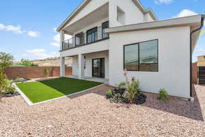 Back of property with a balcony, stucco siding, and a patio