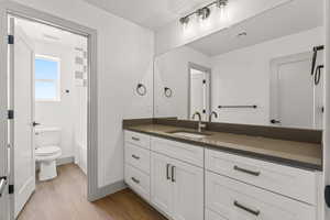 Full bath with vanity, wood finished floors, and shower / washtub combination