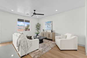 Living room featuring light wood-type flooring, ceiling fan, and recessed lighting