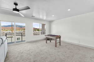 Rec room with a mountain view, light carpet, a ceiling fan, and recessed lighting