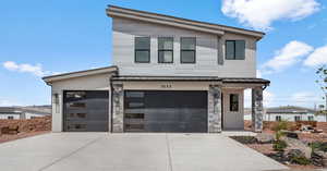 Contemporary house with driveway, a metal roof, and a garage