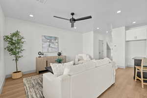 Living room featuring light wood finished floors, ceiling fan, and recessed lighting