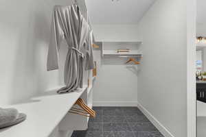 Walk in closet with granite tiled floors