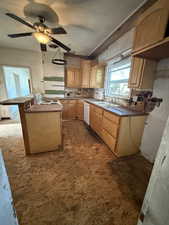 Kitchen with white appliances, ceiling fan, light brown cabinetry, and a kitchen island