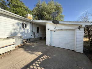 View of side of property with concrete driveway and a garage