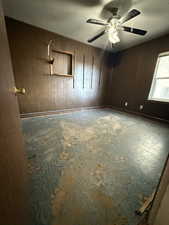 Bedroom featuring wooden walls, a textured ceiling, and ceiling fan