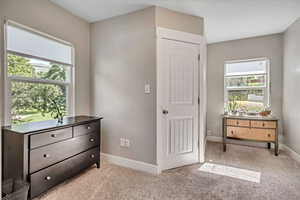 Bedroom with light colored carpet and baseboards