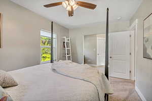 Carpeted bedroom featuring baseboards and a ceiling fan