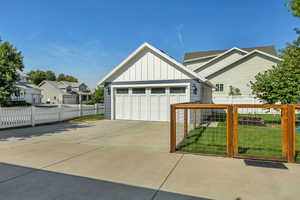 View of front of house featuring board and batten siding, concrete driveway, a garage, and a residential view