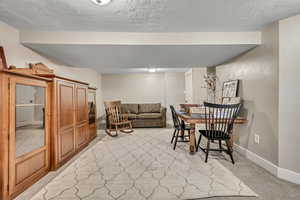 Dining room featuring a textured ceiling and light carpet